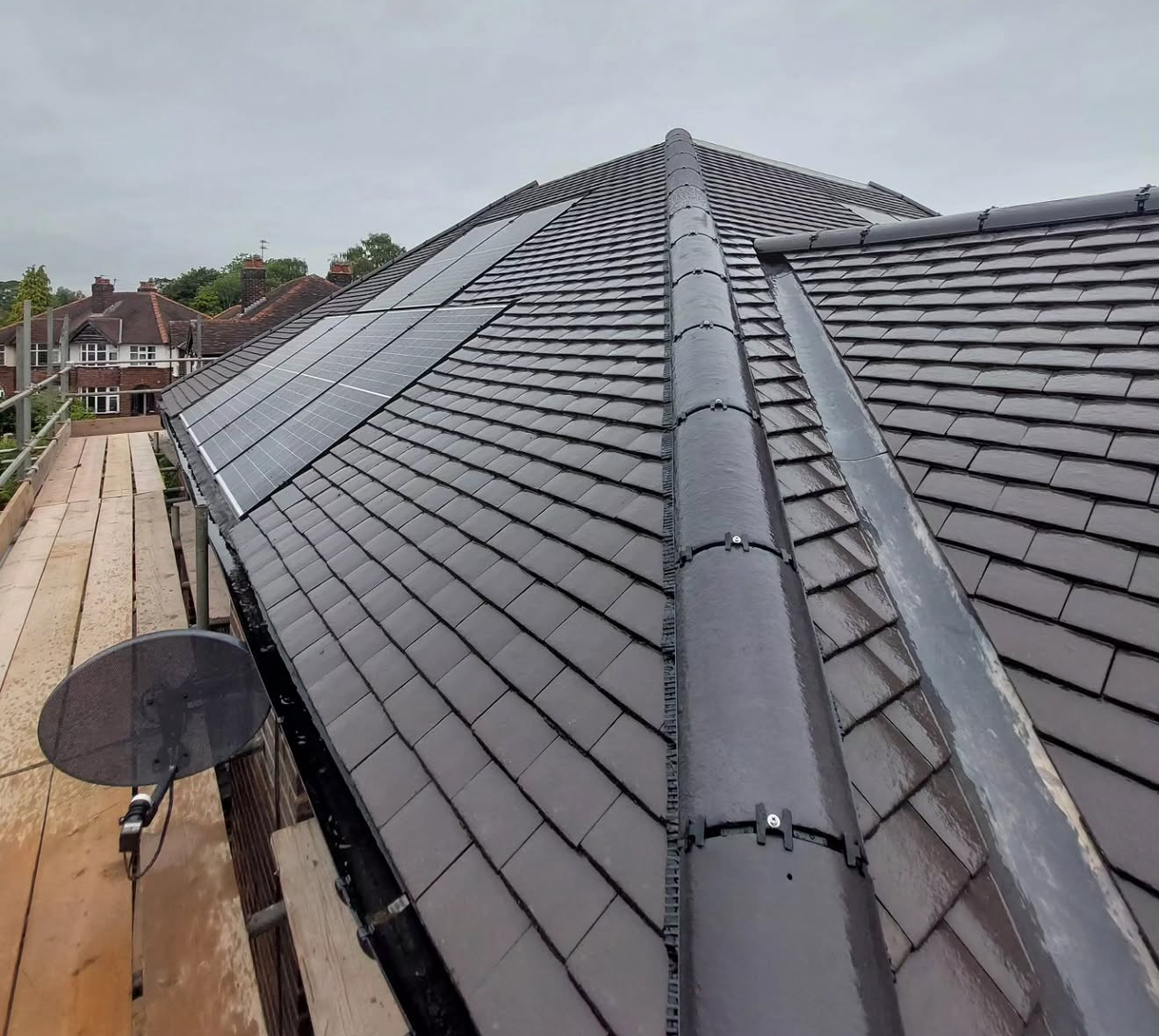 Dry-fix ridge and hip detail on a completed grey slate roof